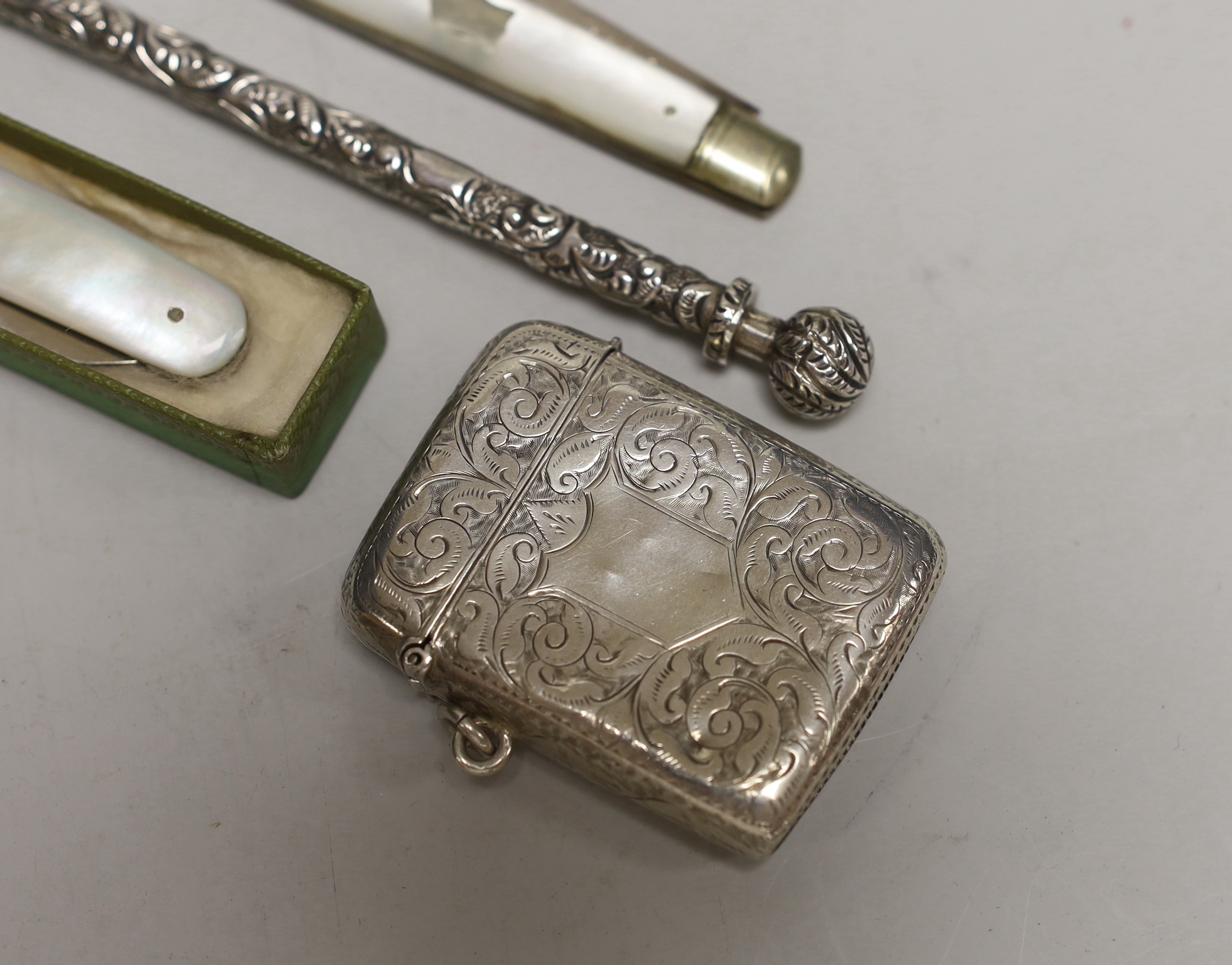 A late Victorian engraved silver vesta case, 53mm, two mother of pearl mounted silver fruit knives and a white metal dip pen.